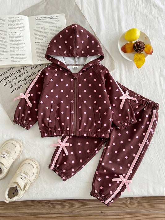Girls Hooded Two Pieces Tracksuit In Brown With Pink Polka Dots. Full-Zip Hooded Jacket And Cuffed Jogger Pants Decorated With Pink Ribbons And Bows.